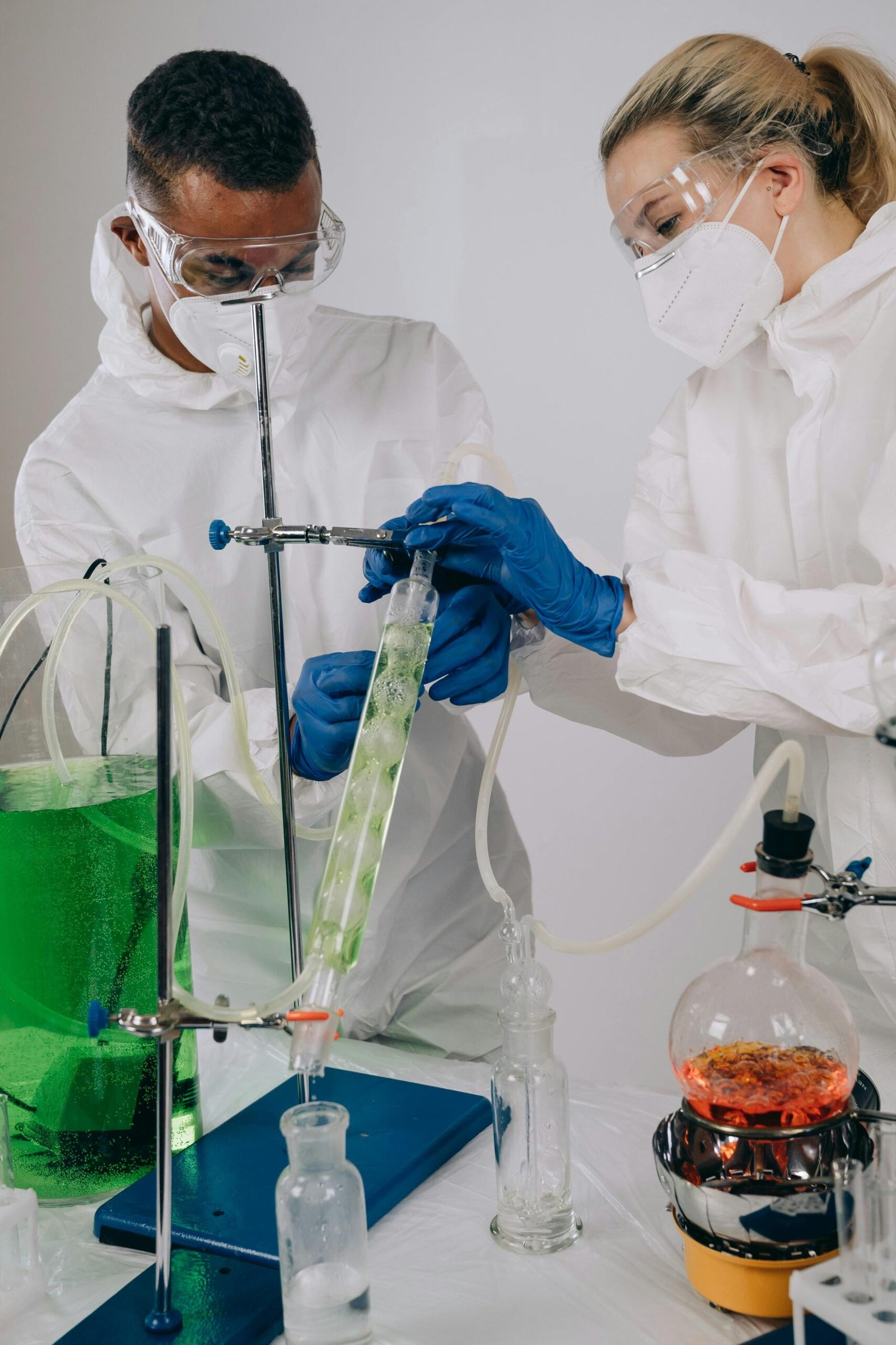 Two scientists in protective gear conducting an experiment in a laboratory setting.